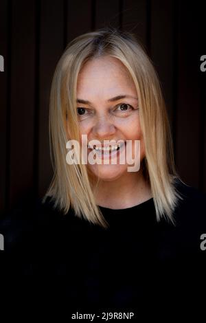 Porträt einer fröhlichen lächelnden Frau auf schwarzem Hintergrund. Lachendes Mädchen. Emotionen des Glücks. Hochwertige Fotos Stockfoto