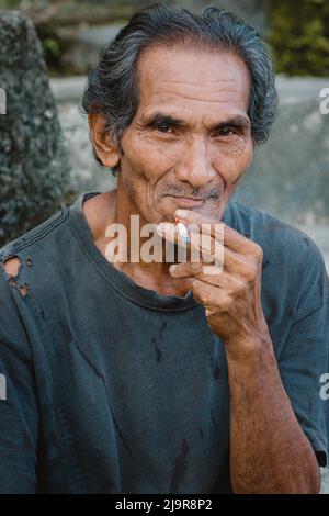 Porträt eines indonesischen alten Mannes aus der Nähe einer Zigarette Stockfoto