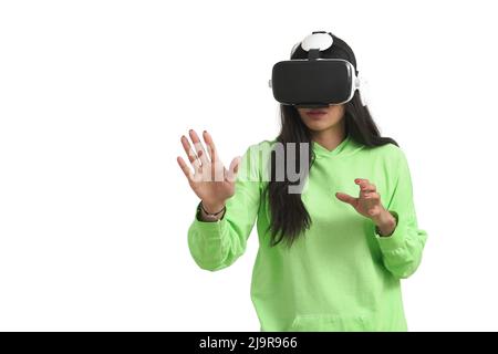 Staunende venezolanische Frau, die während der VR-Erfahrung die Luft berührte, isoliert. Stockfoto