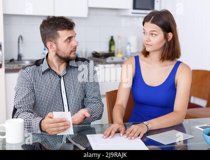 Verärgern Sie das junge Paar mit Bill, der im häuslichen Interieur Konflikte hatte Stockfoto
