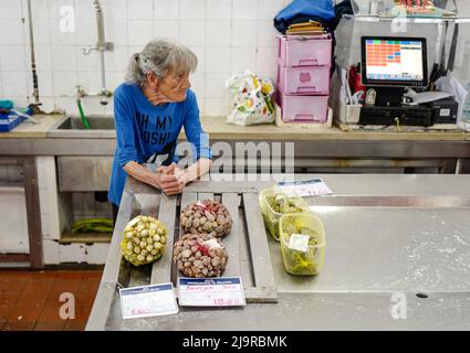 OLHAO, PORTUGAL - Eine Frau verkauft Muscheln auf dem Fischmarkt Stockfoto