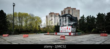 Berlin, Deutschland. 15. April 2022. Ein Denkmal für Ernst Thälmann, den ehemaligen Vorsitzenden der Kommunistischen Partei Deutschlands (KPD), steht vor den Häusern im Ernst Thälmann Park in der Greifswalder Straße im Stadtteil Prenzlauer Berg. Auf der Basis des Denkmals hat jemand Graffiti mit den Worten „Held“ gesetzt. Quelle: Stefan Jaitner/dpa/Alamy Live News Stockfoto