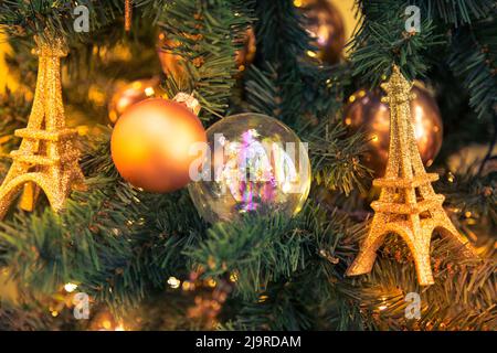 Weihnachtsschmuck mit Eiffelturm auf den Ästen Tanne. Stockfoto