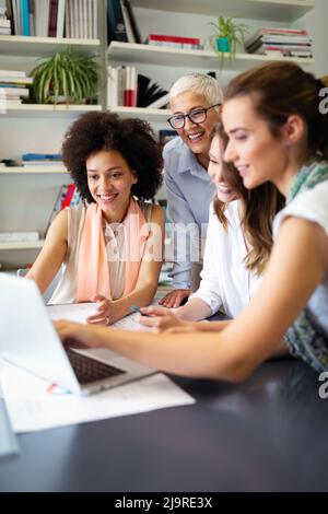 Gruppe von glücklichen Geschäftsleuten, die gemeinsam an einem neuen Projekt in der Unternehmenszentrale arbeiten. Stockfoto