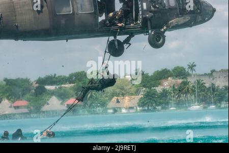 Eine kolumbianische Marine klettert während Helokastextraktionsübungen während des Trainings Tradewinds 2022 (TW22) in der Bacalar Lagune, Mexiko, 10. Mai 2022, eine Leiter, die an einem Hubschrauber der US-Armee Sikorsky UH-60 Black Hawk befestigt ist. TW22 ist eine von der US Southern Command gesponserte, auf die Karibik fokussierte, mehrdimensionale Übung, die im Boden-, Luft-, See- und Cyberbereich durchgeführt wird und den teilnehmenden Nationen die Möglichkeit bietet, gemeinsame, kombinierte und interbehördliche Schulungen durchzuführen, die sich auf die Verbesserung der regionalen Zusammenarbeit und Interoperabilität bei komplexen multinationalen Sicherheitsoperationen konzentrieren. (USA Marine Corps Foto von S Stockfoto