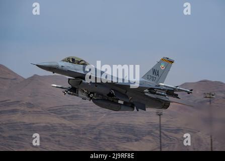 Ein F-16 Falcon, der dem Waffenteam 16. der US Air Force Weapons School zugewiesen wurde, nimmt am 19. Mai 2022 eine Trainingsmission auf der Nellis AFB, Nevada, in Anspruch. Die US Air Force Weapons School unterrichtet Instruktoren auf Graduiertenniveau, die Offiziere und beauftragte Spezialisten der Kampftruppen und der mobilen Luftwaffe in der Ausbildung von Waffen und Taktiken unterstützen. (USA Luftwaffe Foto von William R. Lewis) Stockfoto