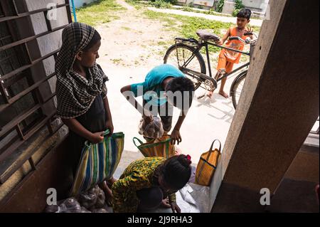 24. Mai 2022, Tehatta, Westbengalen, Indien: Die westbengische Regierung hat Schulen der staatlichen Regierung angewiesen, während der Sommerferien Mittagsessen an Eltern von Schülern zu verteilen, damit den bedürftigen Kindern das Programm nicht entzogen wird. In der Mitteilung hieß es, dass jeder Schüler 2 kg Reis, 2 kg Kartoffeln, 250 Gramm Zucker, 250 Gramm Hülsenfrüchte und ein Stück Seife erhalten würde. So kamen die Schüler in den Sommerferien an eine Grundschule, um ihre Essensartikel zu holen, und einige von ihnen helfen auch, Lebensmittel im Nabin Nagar, Westbengalen, zu geben. (Bild: © Soumrabyata Roy/Pacific Stockfoto