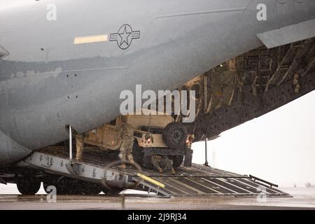 Soldaten der US-Armee, die Bravo Battery, 1. Bataillon, 14. Field Artillery Regiment, 75. Artillery Brigade und US Air Force Airmen, die 167. Airlift Wing, West Virginia, Air National Guard, zugeordnet sind, bereiten die Entladung eines High Mobility Multipurpose Wheeled Vehicle (HMMWV, Oder Humvee) und einem M142 High Mobility Artillery Rocket System während einer HIMARS Rapid Infiltration Übung im Rahmen von DEFENDER-Europe 22 in Bornholm, Dänemark, 24. Mai 2022. DEFENDER-Europe 22 ist eine Reihe von multinationalen Trainingsübungen der US Army Europe und Africa innerhalb der Large Global Scale exe des US European Command Stockfoto