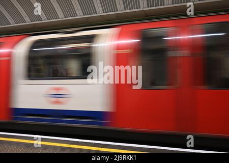 Ein Foto mit langsamer Verschlusszeit von einem Londoner U-Bahn-Zug, der die stationäre Plattform passiert und die Bewegung des U-Bahn-Zuges zeigt. Stockfoto