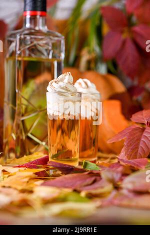 Zwei Wodka mit cremefarbenen Zimt-Kürbis-Pie-Schützen in Schrotgläsern. Diese Getränke sind leicht zu machen und perfekt für den Herbst. Probieren Sie diese alkoholischen Getränke bei Ihnen Stockfoto