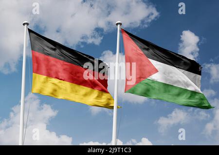 Deutschland und Palästina zwei Flaggen auf Fahnenmasten und blauer, wolkig-blauer Himmel-Hintergrund Stockfoto