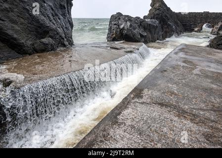 Portpatrick ist ein Dorf und eine Gemeinde an der Westküste der Rhin von Galloway Dumfries & Galloway. Der historische Torbogen widersteht dem Meer noch immer. Stockfoto