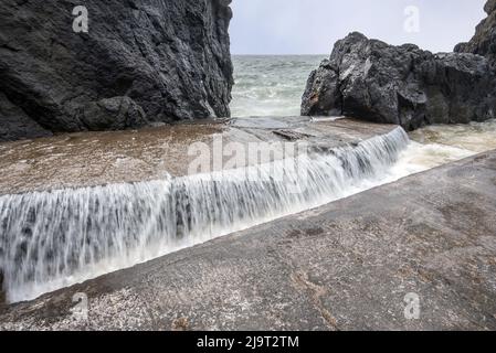 Portpatrick ist ein Dorf und eine Gemeinde an der Westküste der Rhin von Galloway Dumfries & Galloway. Der historische Torbogen widersteht dem Meer noch immer. Stockfoto