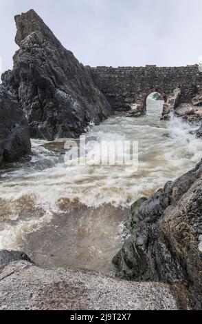 Portpatrick ist ein Dorf und eine Gemeinde an der Westküste der Rhin von Galloway Dumfries & Galloway. Der historische Torbogen widersteht dem Meer noch immer. Stockfoto