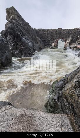 Portpatrick ist ein Dorf und eine Gemeinde an der Westküste der Rhin von Galloway Dumfries & Galloway. Der historische Torbogen widersteht dem Meer noch immer. Stockfoto