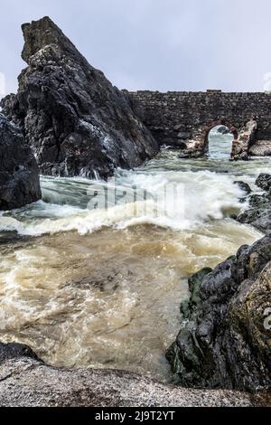 Portpatrick ist ein Dorf und eine Gemeinde an der Westküste der Rhin von Galloway Dumfries & Galloway. Der historische Torbogen widersteht dem Meer noch immer. Stockfoto