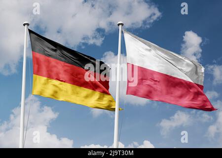 Deutschland und Polen zwei Flaggen auf Fahnenmasten und blau bewölktem Himmel Hintergrund Stockfoto