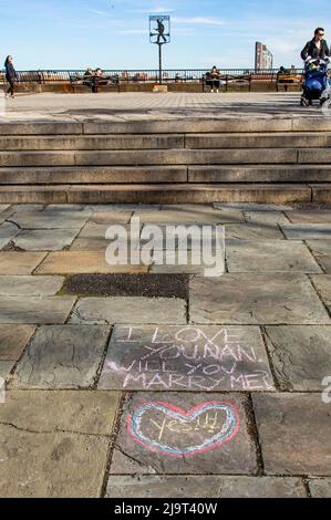 USA, New York City, Manhattan, Upper East Side. John Finley spazieren entlang des East River, Graffiti auf dem Bürgersteig, 'wirst du mich heiraten?' Vorschlag Stockfoto