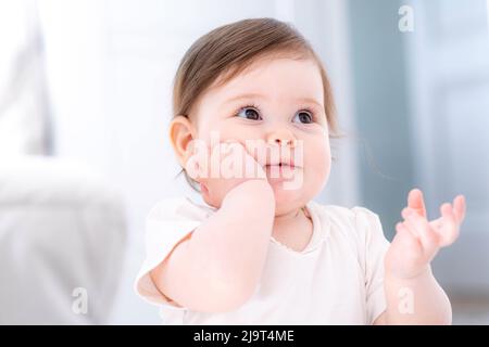 Nachdenklich niedlichen kleinen Baby-Mädchen denken verwirrt von etwas träumen oder mit einer guten Idee, lächelnd und nach oben, Phantasie. Stockfoto