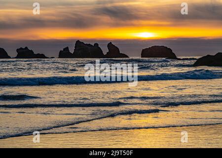 USA, Oregon, Bandon Beach. Das Meer des Pazifischen Ozeans stapelt sich bei Sonnenuntergang. Stockfoto