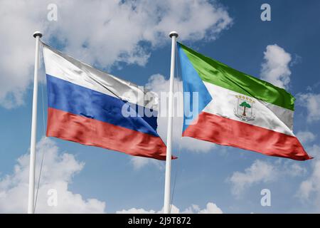 Russland und Äquatorialguinea zwei Flaggen auf Fahnenmasten und blau-trüber Himmel-Hintergrund Stockfoto