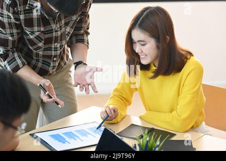 Junger Geschäftsmann erklärt Mitarbeitern während des Treffens im Büro neue Strategien. Stockfoto