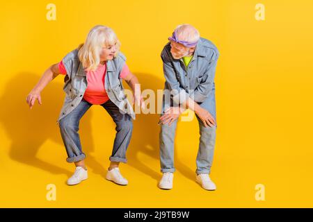 Foto von charmanten funky Freundin Freund gekleidet Denim Outfit mit Spaß leeren Raum isoliert gelben Hintergrund Stockfoto