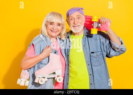 Foto von verträumt glänzend Freundin Freund gekleidet Denim Outfit bereit Reiten lange Board Rollen isoliert gelbe Farbe Hintergrund Stockfoto