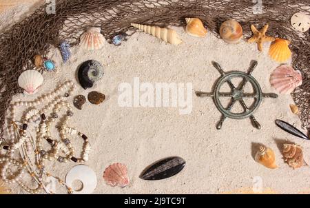 Kapitänsrad mit Fischernetz und Meeresmuscheln nautischen Thema Hintergrund Stockfoto