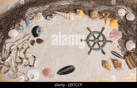 Kapitänsrad mit Fischernetz und Meeresmuscheln nautischen Thema Hintergrund Stockfoto