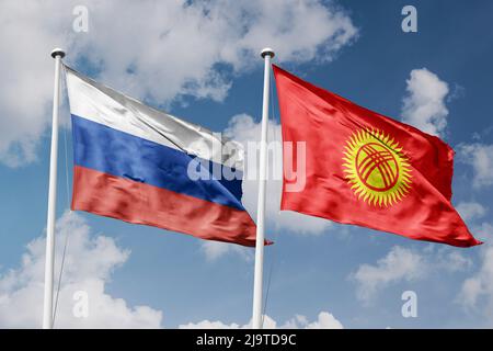 Russland und Kirgisistan zwei Flaggen auf Fahnenmasten und blau-bewölktem Himmel Hintergrund Stockfoto