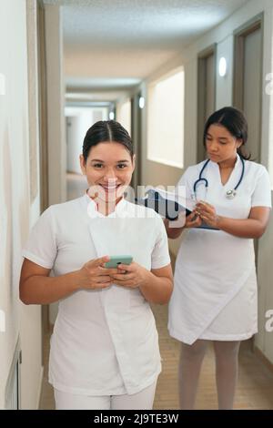 Krankenschwester, die im Krankenhaus ein Mobiltelefon verwendet Stockfoto