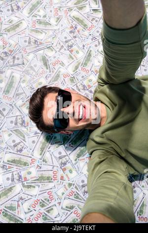 Oben sehen vertikale Foto von fröhlich aufgeregt Person nehmen Selfie legen Cashback isoliert auf Geld Hintergrund Stockfoto