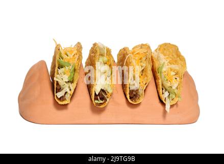 Terrakotta-Taco-Halter mit vier Crunchy Tacos auf weißem Hintergrund Stockfoto