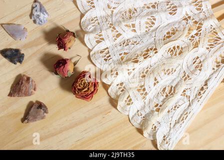 Vintage Lace mit Perlen und indianischen Pfeilspitzen auf Holzhintergrund Stockfoto