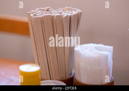 Nahaufnahme der zwanglosen chinesischen Restauranttische mit Essstäbchen, Saucen, Zahnstochern und Gewürzflaschen. Stockfoto