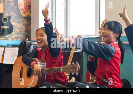 (220525) -- HARBIN, 25. Mai 2022 (Xinhua) -- Kinder im Musikunterricht üben an der zentralen Grundschule der Stadt Renmin in Anda, nordöstlich der Provinz Heilongjiang, am 24. Mai 2022 für Bandaufführung. Die Musikklasse der Grundschule wurde im April 2019 gegründet. Die Lehrer der Klasse passen die Texte der populären Lieder an, damit die Kinder singen können, und unterrichten sie ihnen dann während der Mittagspause oder der Clubaktivität. Die Kinder-Chorus-Videos wurden auf kurzen Videoplattform veröffentlicht, die von vielen Netzzenen beliebt waren und über 1 Millionen Fans verdienten. Mit dem in Stockfoto