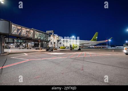 Nachtflughafen mit vielen Flugzeugen an der Start- und Landebahn. Stockfoto