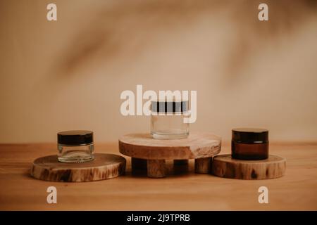 Holzpodium mit Containern und beigem Hintergrund; Stockfoto