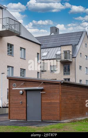 Lagerhaus im skandinavischen Stil aus braunem Holz vor dem modernen Apartmentgebäude Stockfoto