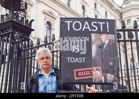 London, England, Großbritannien. 25.. Mai 2022. Ein Protestler hält ein Schild mit dem Titel „Johnson is Toast“. Anti-Boris-Johnson-Demonstranten versammelten sich vor der Downing Street, als der Bericht von Se Gray über den Partygate-Skandal veröffentlicht wurde. (Bild: © Vuk Valcic/ZUMA Press Wire) Bild: ZUMA Press, Inc./Alamy Live News Stockfoto