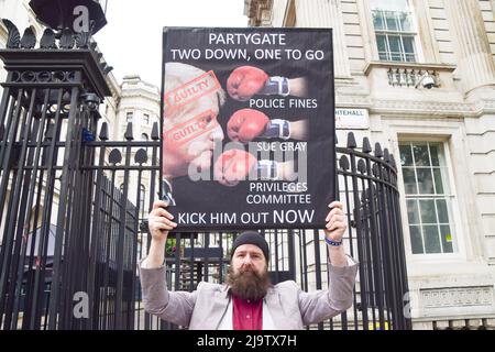 London, England, Großbritannien. 25.. Mai 2022. Ein Protestler hält ein Zeichen, das Boris Johnson zum ''rausgeworfen'' aufruft. Anti-Boris-Johnson-Demonstranten versammelten sich vor der Downing Street, als der Bericht von Se Gray über den Partygate-Skandal veröffentlicht wurde. (Bild: © Vuk Valcic/ZUMA Press Wire) Stockfoto