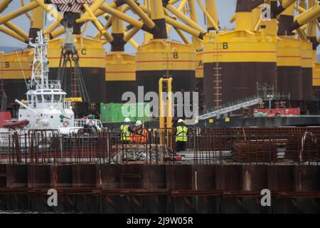 ÖLKRISE.Ölplattformen Cromarty Firth, die wieder in Betrieb sind, plus Wind-Trubine-Beine aus China. Stockfoto