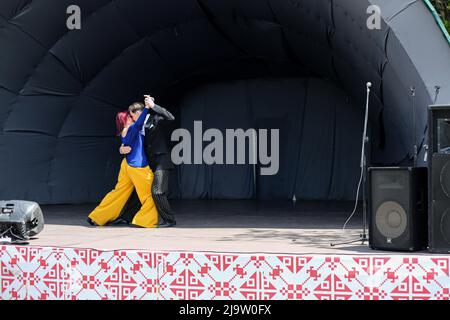 Ein Paar tritt während eines Konzerts im Rahmen der militärisch-patriotischen Aktion „Support Yours“ in einem Tango auf. Im Park namens T.G. Schewtschenko, ein Konzert des Offiziershauses fand auf der Rakuschka-Bühne statt. Ziel der Aktion ist es, die Streitkräfte und die Moral der Bevölkerung zu unterstützen. Stockfoto