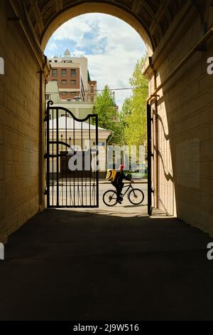 Moskau, Russland - 25. Februar 2022: Kurier von Yandex lavka auf hausgemachtem Moped liefert Lebensmittel und Fahrten auf Bürgersteig im Winter Stockfoto