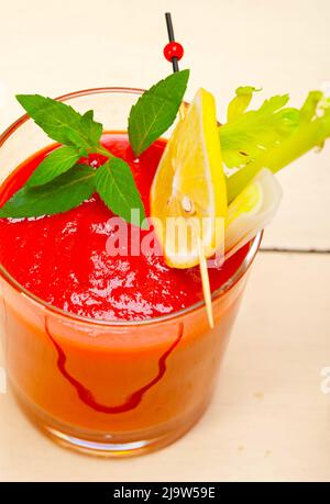 frischer Saft Gazpacho Tomatensuppe auf ein Glas über weiße Holz Tisch Stockfoto