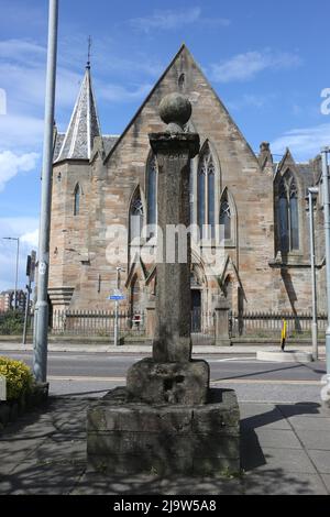 Ayr, Ayrshire, Schottland, Großbritannien. Das Mercat-Kreuz von Newton auf Ayr. Das Newton Market Cross steht jetzt in der Nähe der New Bridge. Der ursprüngliche Standort befand sich in der Mitte der Hauptstraße, gegenüber der Cross Street, heute King Street. Es wurde von dort ein paar Jahre vor 1847 verlegt. Das Kreuz hat einen einfachen quadratischen Schaft mit einer Basis. Rund um die Hauptstadt stehen die Worte 'Newton Cross - 1778'. Im Hintergrund ist der wettergetragene 2,0m hohe abgeschrägte Schaft und der 0,7m quadratische Sockel auf einem modernen Sockel zu sehen, der von einem quadratischen Sockel mit Kugelfinial überragt wird. Die Inschrift ist kaum lesbar. Stockfoto