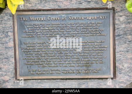 Ayr, Ayrshire, Schottland, Großbritannien. Das Mercat-Kreuz von Newton auf Ayr. Das Newton Market Cross steht jetzt in der Nähe der New Bridge. Der ursprüngliche Standort befand sich in der Mitte der Hauptstraße, gegenüber der Cross Street, heute King Street. Es wurde von dort ein paar Jahre vor 1847 verlegt. Das Kreuz hat einen einfachen quadratischen Schaft mit einer Basis. Rund um die Hauptstadt stehen die Worte 'Newton Cross - 1778'. Im Hintergrund ist der wettergetragene 2,0m hohe abgeschrägte Schaft und der 0,7m quadratische Sockel auf einem modernen Sockel zu sehen, der von einem quadratischen Sockel mit Kugelfinial überragt wird. Die Inschrift ist kaum lesbar. Stockfoto