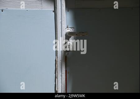 Altes traditionelles ländliches Haus hellblau hölzerne Eingangstür mit einem lackierten Metallgriff und Schlüsselloch. Stockfoto