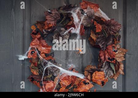 Bunte Kranz für halloween hängen an hölzernen Haus Tür aus alten orange Ahornblätter.Spider Web.Decorating von porch.Home, outdoort, Straße decora Stockfoto